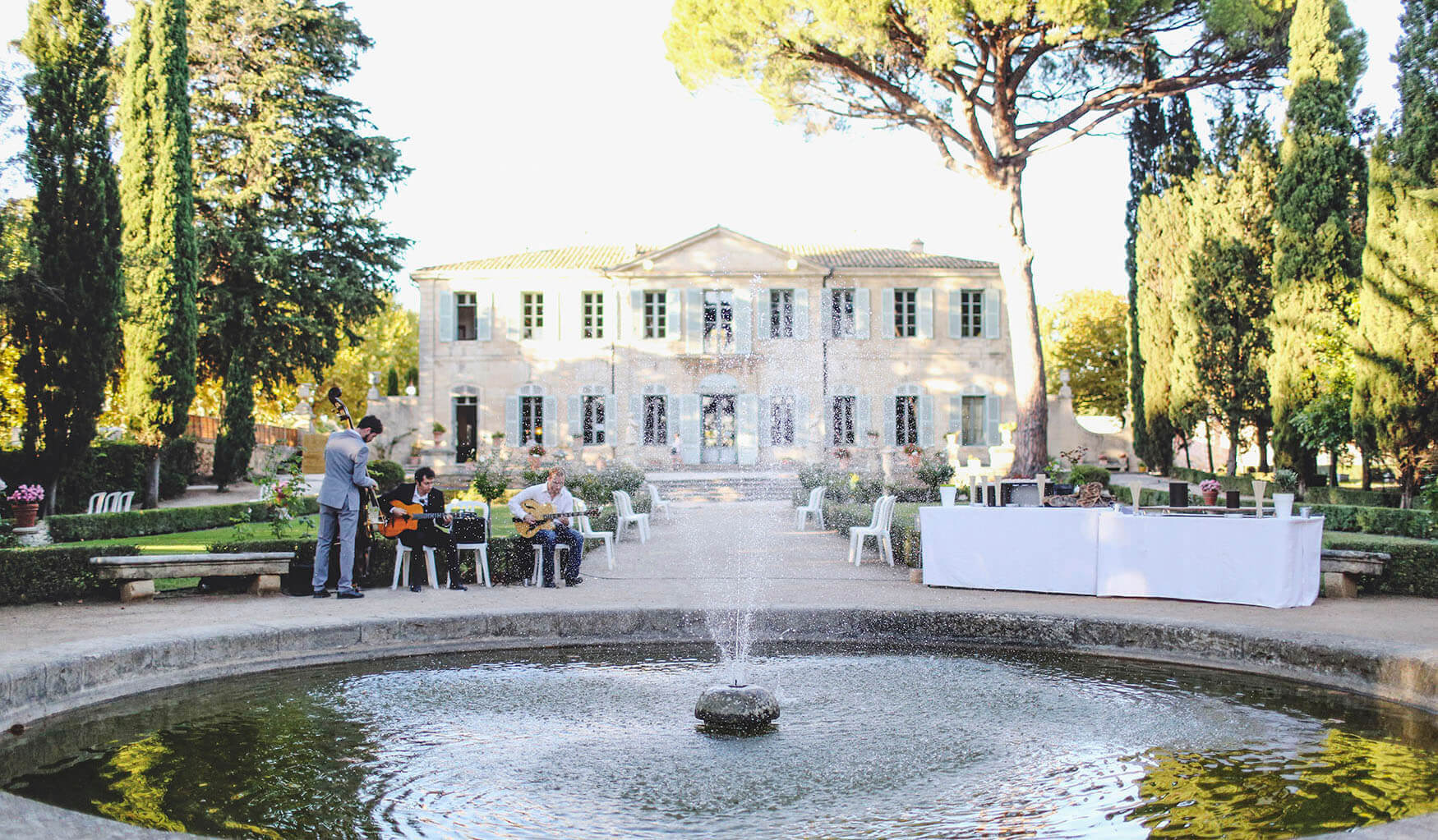 Cordes Nomades gypsy jazz trio performing beside a fountain at a château wedding near Montpellier