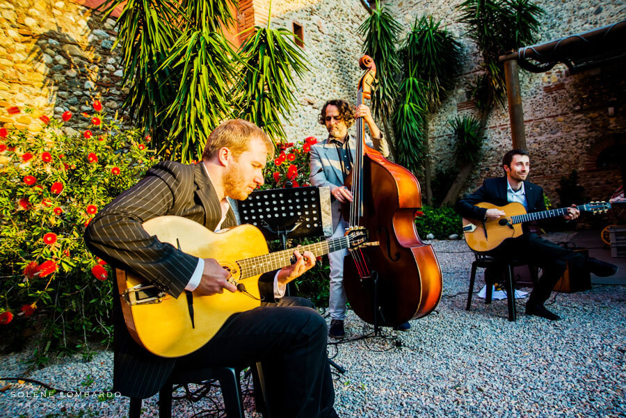 Cordes Nomades gypsy jazz trio performing in a château courtyard during a wedding reception